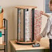 A man standing next to a group of rolls of wrapping paper on a Bulman Suzette vertical rack.