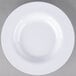 A close-up of a Carlisle white melamine bowl with a white rim.