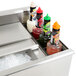 An Eagle Group underbar cocktail and ice bin filled with bottles of liquid and condiments.