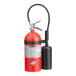 A red fire extinguisher with a black cap and hose.