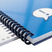 A close-up of a blue spiral notebook with Swingline GBC ProClick binding.
