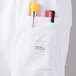 A white Mercer Culinary Millennia Air cook jacket with a mesh back and a pocket with pens.