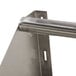 An Advance Tabco wall mounted metal rack shelf with metal tubular bars.