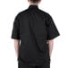 A person wearing a black Mercer Culinary cook jacket with cloth knot buttons.