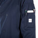 a person wearing a blue jacket with a pocket full of pens and a phone