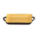 A rectangular yellow stoneware baking dish with a brown bottom and a handle.