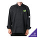 A man wearing a black Mercer Culinary chef coat with a green logo on a counter in a professional kitchen.