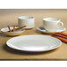 A white Homer Laughlin Alexa bouillon bowl on a white plate with a cinnamon stick.