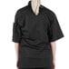 A woman wearing a black Mercer Culinary chef jacket.