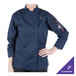 A woman wearing a Mercer Culinary navy chef's coat.