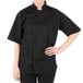 A woman wearing a black Mercer Culinary chef coat.