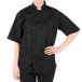 A woman wearing a black Mercer Culinary chef coat.