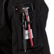 A Mercer Culinary Millennia women's black chef coat with a phone and pen in the pocket.