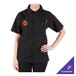 A person wearing a Mercer Culinary black cook shirt with a logo on the counter in a professional kitchen.