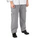A person wearing Mercer Culinary Genesis houndstooth chef pants with a pocket.