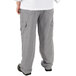 A person wearing Mercer Culinary houndstooth chef pants and a white shirt.