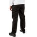 The lower half of a person wearing Mercer Culinary Millennia women's black chef pants.