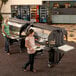 Two women using a Cambro black 6' Versa food/salad bar.