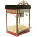 A Benchmark USA red popcorn machine with popcorn in it.