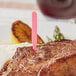 A piece of meat with a Royal Paper pink medium rare steak marker in it.