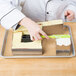 A person using a Matfer Bourgeat deconstructed wedding cake frame to cut a cake.