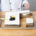 A chef using a Matfer Bourgeat French Style cake frame to cut a cake.