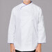 A woman wearing a white Mercer Culinary chef coat with royal blue piping.