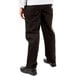 A person wearing Mercer Culinary black chef pants with a white shirt.