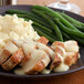 A plate of food with mashed potatoes, green beans, and Vanee Roasted Chicken Gravy.