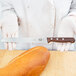 A person using a Victorinox bread knife to slice a loaf of bread.