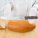 A person using a Victorinox bread knife to slice a loaf of bread.