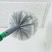 A person using an Unger cobweb duster brush to clean a ceiling.