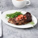 A Reserve by Libbey bone china oval platter with steak, green beans, and tomatoes.