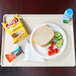 A Cambro dietary tray with a sandwich, vegetables, and a drink.