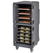 A Cambro Pro Cart Ultra food holding cabinet with trays of food on a large metal cart.