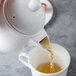 A Reserve by Libbey bone china teapot pouring tea into a cup.