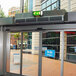 A glass door with a green sign reading "Air Curtain" above a Schwank surface mounted air curtain.