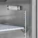 An Avantco stainless steel refrigerated sandwich prep table with a thermometer on a shelf.