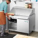 An Avantco stainless steel refrigerator on a counter in a professional kitchen.