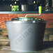 A gray and green Matfer Bourgeat salad spinner with a handle.