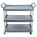 A Rubbermaid gray three shelf utility cart with wheels.