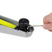 A hand using a yellow FLAT Tech table pad tool to adjust a table pad.