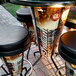 An Indian Motorcycle round bar height table with a group of stools around it on a brick patio.