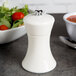 A white Fletchers' Mill Sierra salt mill on a table with a bowl of salad and a spoon.