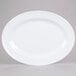 A white oval melamine platter with a white rim.