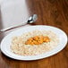 A Water Lily melamine platter with rice and meat on a table.