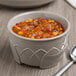 A bowl of chili with beans and corn in a Fenwick insulated bowl with a spoon.