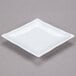 A bright white square porcelain plate with a bamboo pattern on the rim.