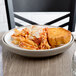 A plate of pasta and bread on a Dinex Latte Insulated Meal Delivery Base.