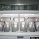 A white Excellence gelato dipping cabinet with seven metal containers of gelato inside.
